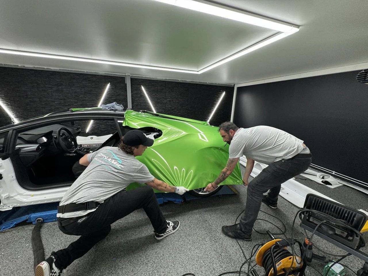 Pose d’un film vert sur un véhicule dans l’atelier